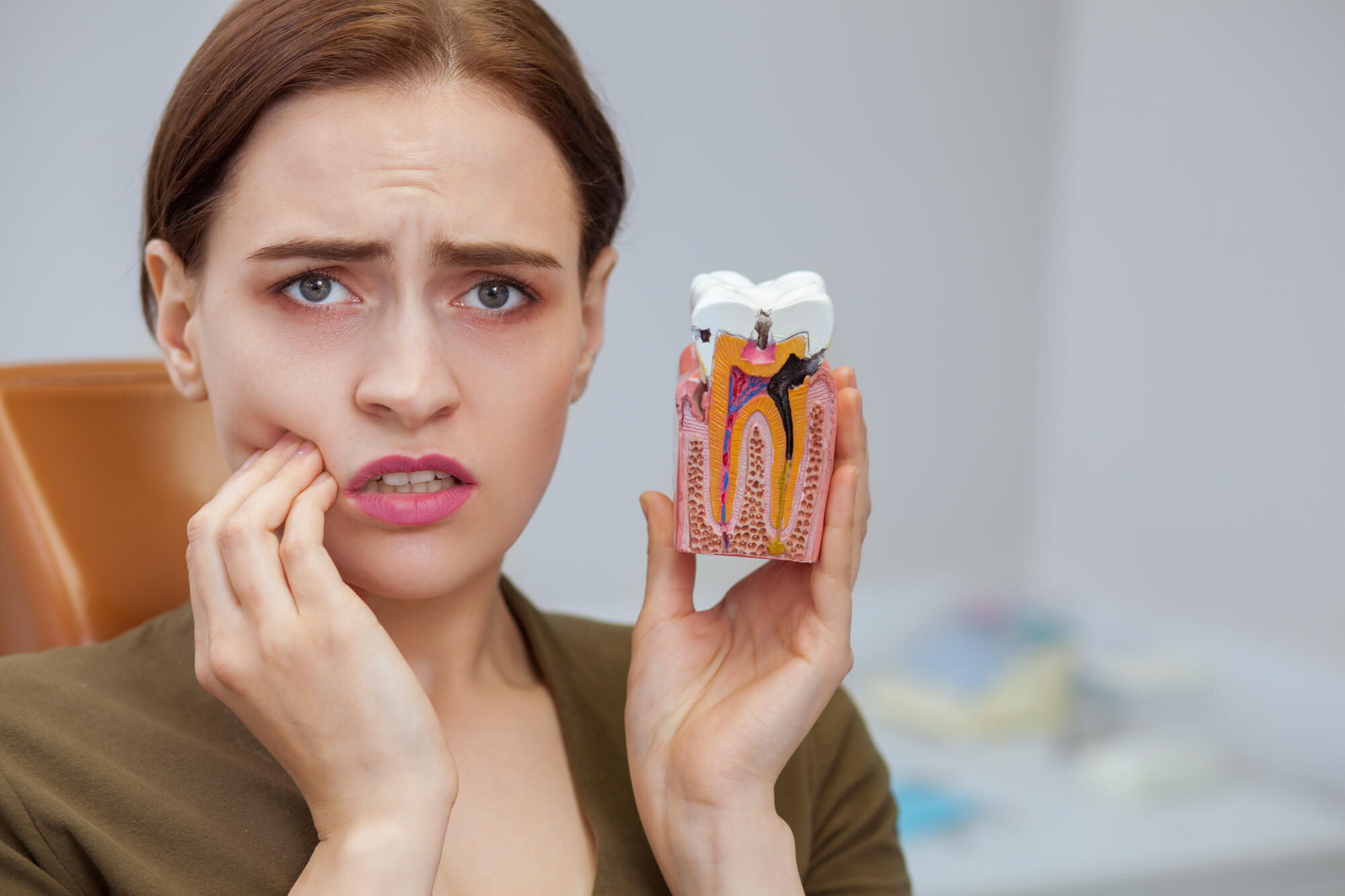 A woman with a toothache needing an emergency dentist in Hialeah