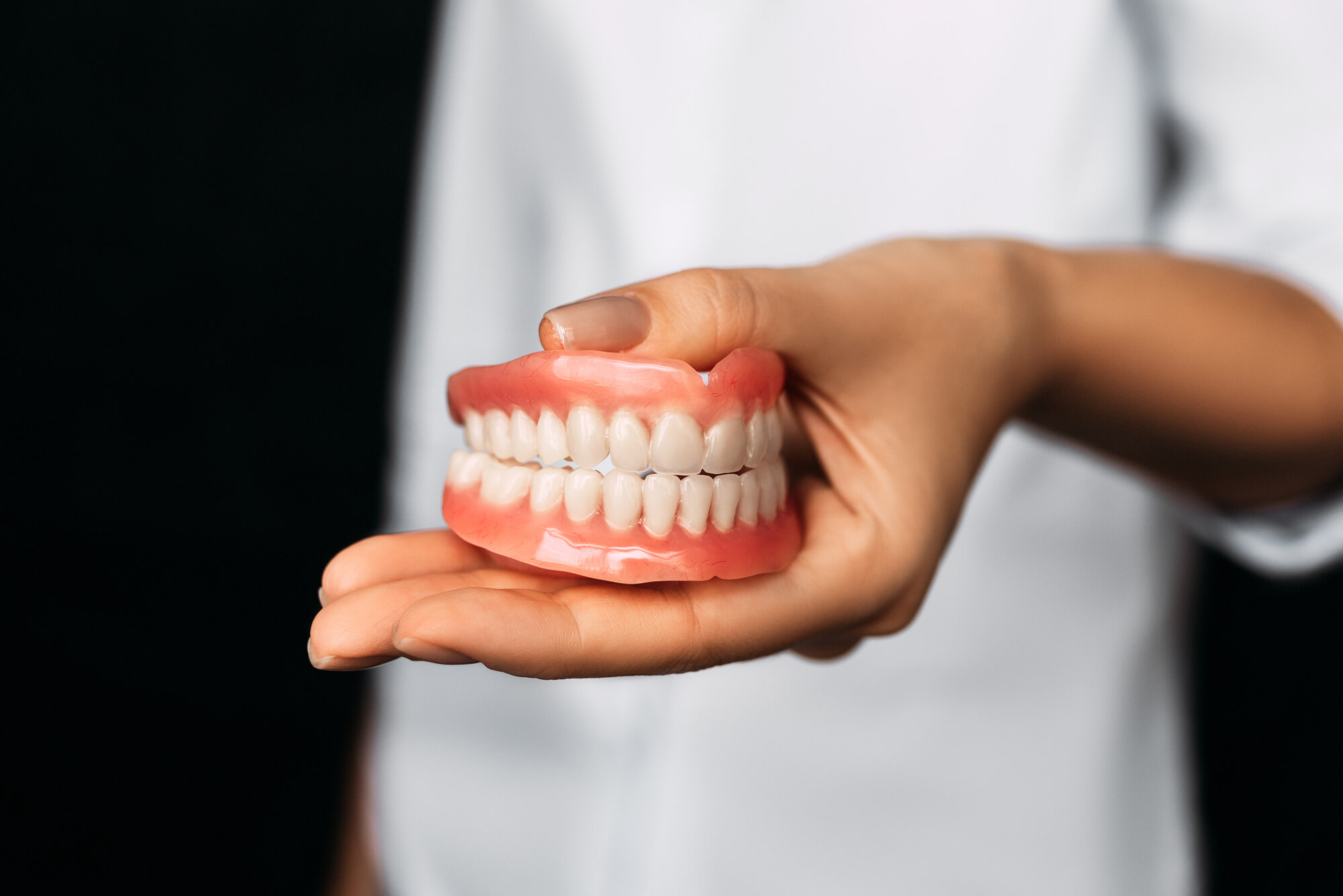 Dentist holding dentures in Pembroke Pines