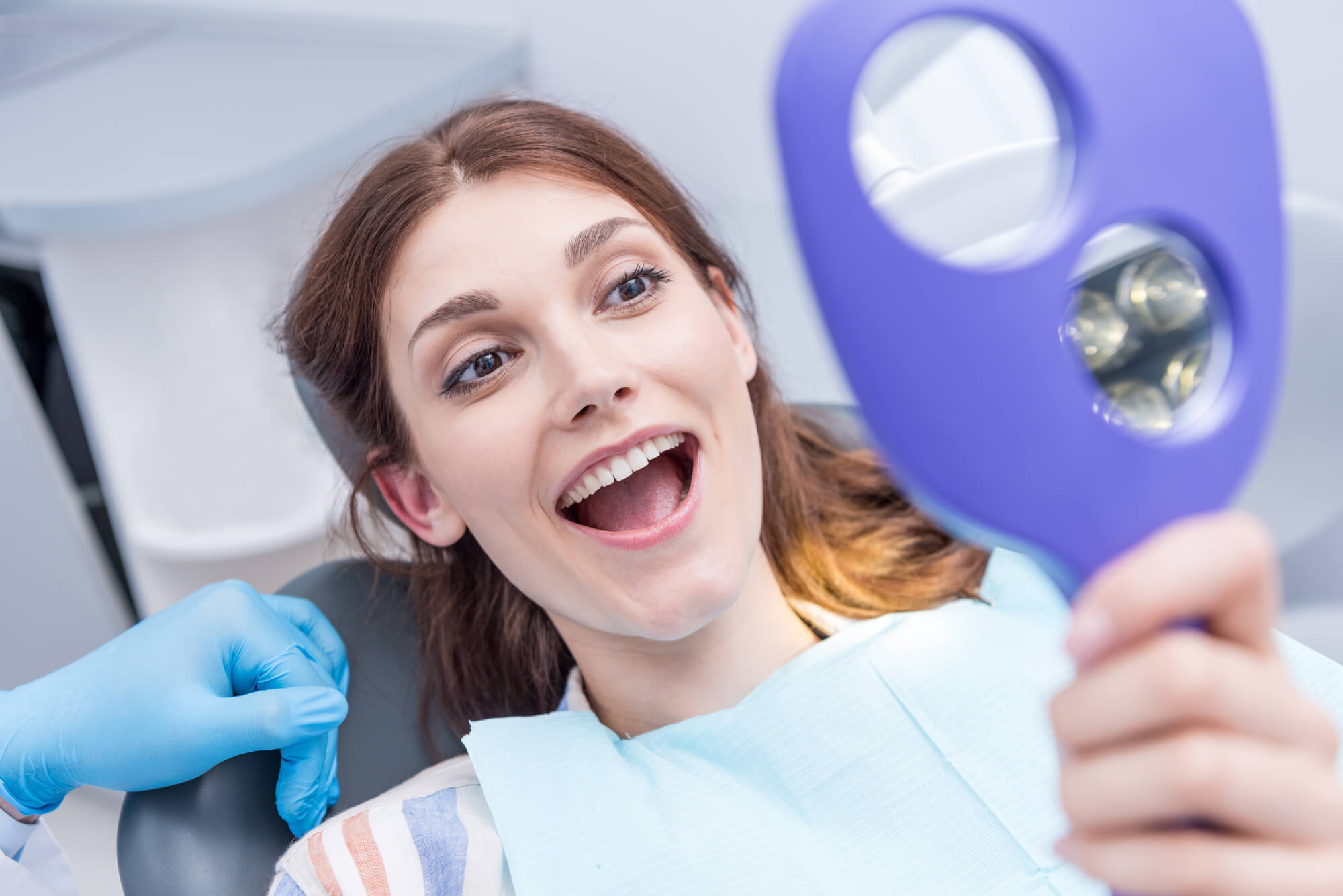 woman at the dentist smiling after teeth whitening in Miami