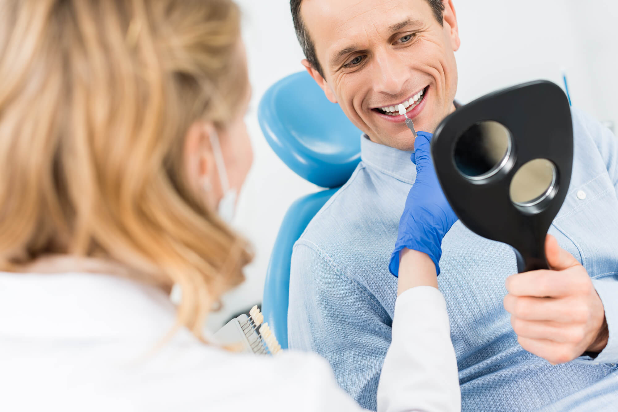 dentist helping patient choose crown for a dental implant Miami